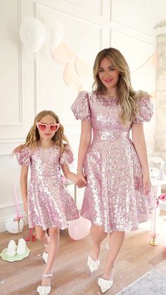 Pink sequin. Scoop neckline. Short puff sleeve with elastic band. Knee length skirt. Exposed back zipper. Fully lined. Fabric is non-stretch. Fabric Shell: 100% Polyester, Lining: 100% Polyester. Hand wash only; lay flat to dry, Low iron only. Available in sizes 00, 0, 2, 4, 6, 8, 10, 12, 14, 16, 16W, 18W, 20W, 22W, 24W, 26W, 28W, 30W, 32W, + 34W & matching minis!! pink sequin dress, sequins, party dress, party outfit, pink dress, plus size fashion, matching mom and kid outfit Party Outfit Pink, Bejeweled Dress, Short Flare Dress, Kid Outfit, Ivy City Co, Pink Sequin Dress, Matching Mom, Short Puff Sleeve, Outfit Pink