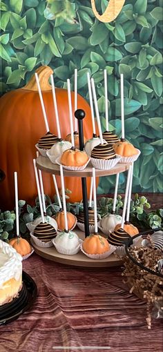 there are many desserts on the table with pumpkins in the backround