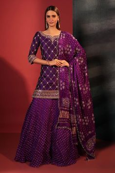 Purple kurta with gota foil embroidery in checkered pattern and leaf neckline. Paired with attached cancan skirt with bandhani woven motifs and dupatta.
Components: 3
Pattern: Embroidery, Woven
Type Of Work: Gota foil, bandhani
Neckline: Leaf neck
Sleeve Type: Three quarter
Fabric: Silk
Color: Purple
Other Details: 
Tassel embellished dupatta
Attached lining
Length:
Kurta: 36 inches
Skirt: 42 inches
Disclaimer: These are made to order designer styles, hence expect a slight variation from the ima Wedding Sharara, Designer Sharara Suits, Kurta Skirt, Shamita Shetty, Plazzo Suits, Palazzo Suit, Sharara Suit, Anarkali Suit, Georgette Fabric