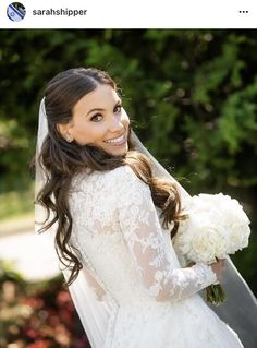 a woman in a wedding dress holding a bouquet and smiling at the camera while standing outside