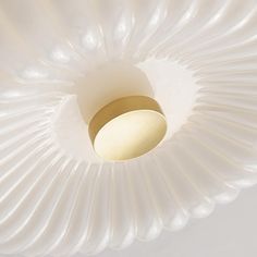 a close up of a white ceiling light fixture with a gold ring in the center