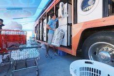 two people loading items onto a bus