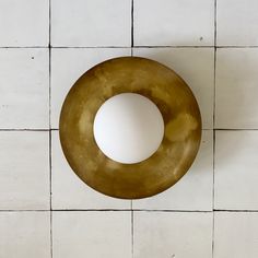 an overhead view of a white and gold object on a tile floor with tiles in the background