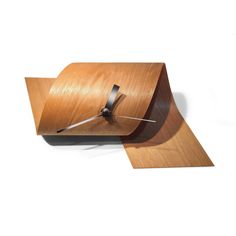 a wooden clock that is on top of a white surface and has a black hands