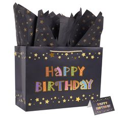 a black birthday bag with gold stars and the words happy birthday on it next to a card