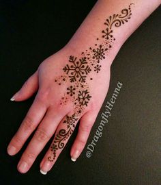 a woman's hand with a henna tattoo on it