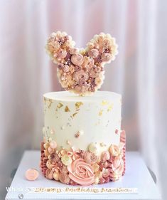 a white cake with pink and gold decorations