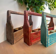 three wooden utensils sitting on top of a table next to a potted plant