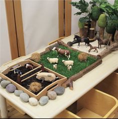 a table topped with fake farm animals and grass