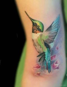 a tattoo with a hummingbird on it's side