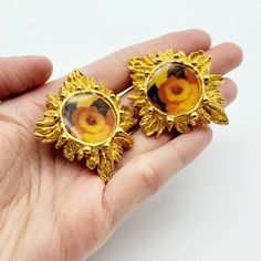 Very rare vintage Christian Lacroix flower earrings in very good condition in general. However, the clip of one earring was repaired (I put photos back to back so that you could see the difference) and it works perfectly.Brand: Christian LacroixColor: GoldtoneMaterial: There's a clear layer of resin over the flower print. Very rare find from Christian LacroixCondition: Very good conditionMeasurements: Height 4.7 cm x Width 4 cmAccessories: NoneCondition Rankings:Mint - Perfect condition and pres Vintage Gold Flower Clip-on Earrings, Handmade Retro Gold Clip-on Earrings, Handmade Gold Retro Clip-on Earrings, Vintage Flower-shaped Clip-on Earrings, Vintage Clip-on Flower Earrings, Vintage Metal Flower Earrings, Vintage Metal Flower Earrings For Pierced Ears, Vintage Handmade Metal Clip-on Earrings, Handmade Vintage Metal Clip-on Earrings