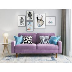 a living room with purple couches and pictures on the wall above it, along with a lamp