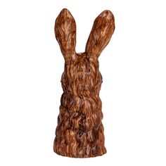 a wooden sculpture of a rabbit's head with curly brown hair and ears, on a white background