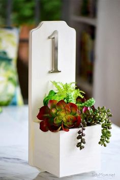 a small wooden planter with succulents in it