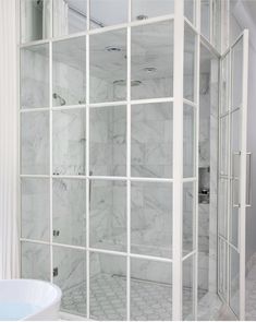 a white bath tub sitting next to a walk in shower