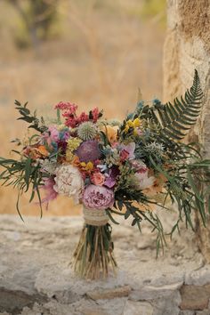 a bouquet of flowers sitting on top of a rock