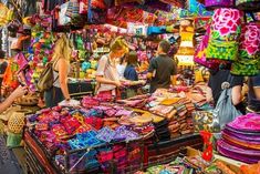 people shopping in an outdoor market with colorful items