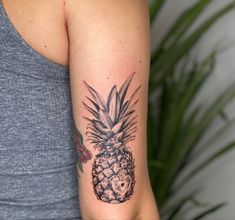 a woman's arm with a pineapple tattoo on it