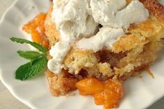 a piece of pie on a plate with whipped cream and mint leaf garnish