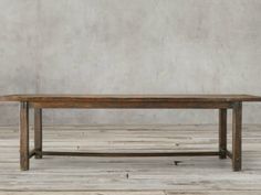 a wooden table sitting on top of a hard wood floor next to a white wall