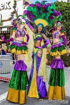 three women in colorful costumes standing on the street