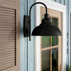 an outdoor light hanging from the side of a house next to a window with shutters