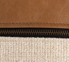 a close up view of the zippers on a brown and white handmade purse