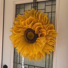 a sunflower is hanging on the front door to decorate it's glass doors