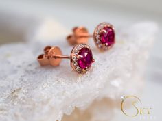 Rose gold ruby halo earrings, with a delicate yet eye capturing design. The stones have a stunning dark red color that gives you a mesmerizing effect with the accented stones all around. The Ruby is the birthstone of July. It represents love and passion. For centuries, this gem has been considered the king of all gems for its rarity, hardness (second only to a diamond), beauty and apparently mystical powers. Rubies have been the prized possession of emperors and kings throughout the ages, and to Rose Gold Ruby Earrings For Gifts, Anniversary Ruby Earrings With Halo Setting, Rose Gold Ruby Round Earrings, Ruby Halo Earrings For Wedding, Wedding Ruby Earrings With Halo Design, Ruby Earrings With Halo Design For Wedding, Ruby Halo Design Earrings For Wedding, Red Halo Design Earrings For Wedding, Ruby Earrings With Halo Setting