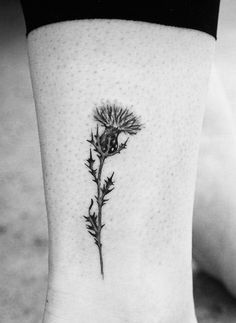 a black and white photo of a flower on the ankle