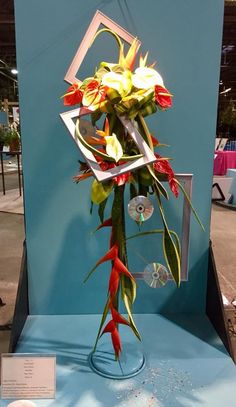 a bouquet of flowers sitting on top of a blue display case at a flower show