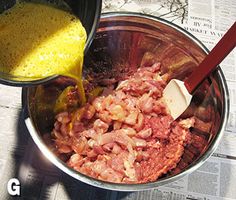 a metal bowl filled with meat next to a red spatula