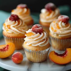 some cupcakes with frosting and fruit on top are sitting on a plate