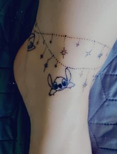 a woman's foot with a small tattoo on the side of her leg and stars