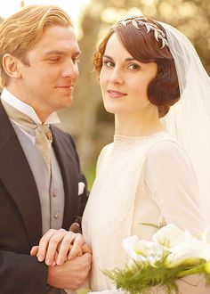 a man and woman standing next to each other in formal wear, dressed in old fashion clothing