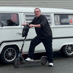 an older man on a scooter in front of a van