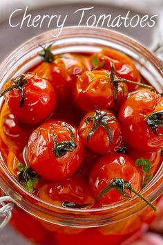 a jar filled with lots of tomatoes on top of a table