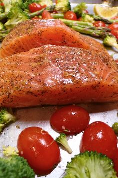 salmon, broccoli and cherry tomatoes on a sheet of foil with seasoning