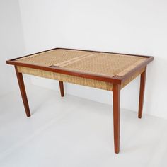 a table made out of wicker and wood with one section missing from the top