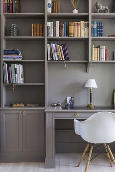 an office with gray bookcases and white chair