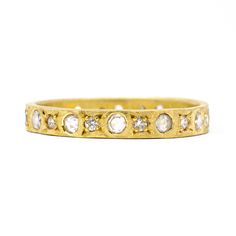 a yellow gold band with five diamonds on the side and four small round stones in the middle