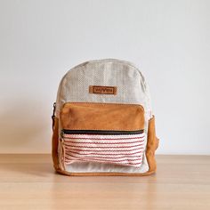 Fashionable and sporty, the mini backpack hails from the WoVen collection in Nepal. Made from hand-loomed cotton material, the bag features an earthy tone of Allo and caramel suede leather trim. This cute, practical mini backpack is ideal for everyday essentials! Casual Beige Backpack With Leather Handles, Beige Backpack With Leather Trim For Everyday Use, Casual Brown Backpack With Leather Handles, Casual Leather Trim Standard Backpack, Everyday Beige Backpack With Leather Trim, Casual Backpack With Leather Handles, Casual Brown Backpack With Canvas Lining, Casual School Backpack With Leather Handles, Casual Backpack With Leather Handles For School