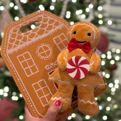 a hand holding up a gingerbread christmas ornament