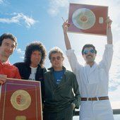 four people are posing for a photo while holding up a plaque