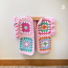 there is a crocheted baby booties hanging on the wall