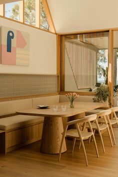 a dining room with wooden tables and benches in front of large windows that overlook the water