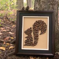 the silhouette of a person is made out of pine cones in front of a tree