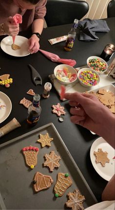 some people are making christmas cookies on a table