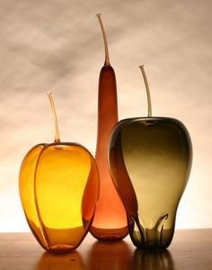 three different colored vases sitting on top of a table