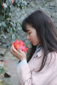 a woman holding a flower in her hands